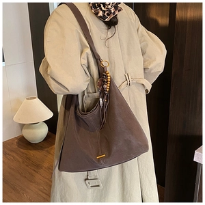 Deep brown leather hobo bag with wooden bead tassel and elegant gold metal hardware