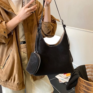 Detail of vintage black matte tote bag with contrast stitching and small crescent pouch