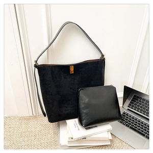 Chic black suede tote bag and matching leather pouch set displayed in office setting