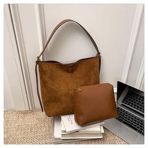 Detail of brown suede tote bag and smooth leather pouch for office work commute