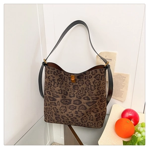 Detail of leopard print tote bag with golden twist lock and black leather shoulder strap