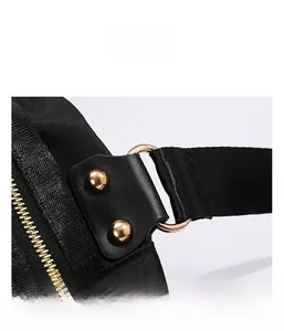 Détail de l'anneau en D doré et rivets sur le sac à bandoulière en oxford noir