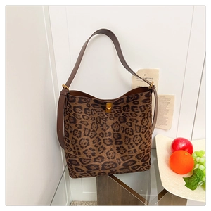 Detailed view of the leopard print bucket bag featuring a gold-toned twist-lock closure