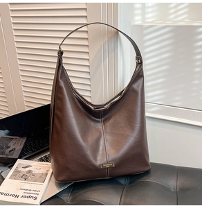 Detail of deep brown faux leather tote bag with longitudinal stitching and shoulder strap