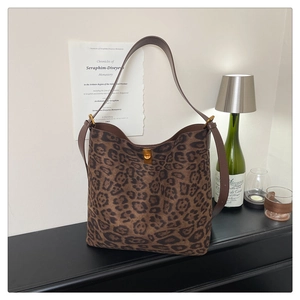 Detailed close-up of leopard print tote bag featuring a metallic turn-lock closure