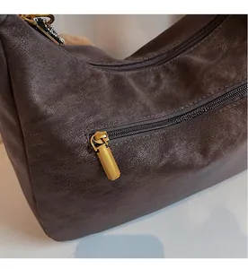 Detail of the smooth metallic zipper and fine leather texture on the brown tote bag