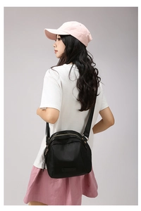 Vue arrière d'un sac bandoulière en nylon noir avec zips dorés et sangle réglable