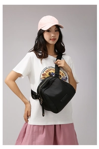 Détail du sac de poitrine en nylon noir avec bandoulière réglable et zip doré