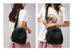 Détail du sac bandoulière en nylon noir imperméable avec trois fermetures éclair dorées