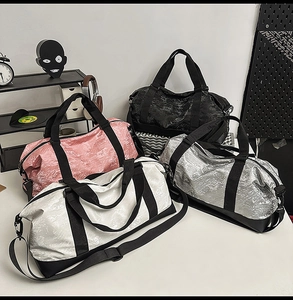 Close-up of travel bags in pink, white, silver, and black with pleated waterproof texture