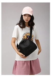 Détail du sac bandoulière en nylon oxford noir avec sangle réglable et finitions dorées