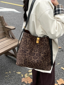 Fashion leopard print tote bag with golden metal clasp shown in a street lifestyle view
