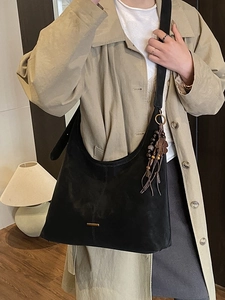 Classic black matte tote bag with boho tassel detail and gold metal trim for women