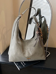 Minimalist grey hobo shoulder bag with leather tassels and mirror reflection