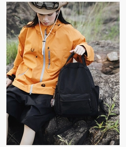 Outdoor lifestyle shot of a durable black backpack on a hiker in a scenic rocky setting
