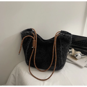 Détail d'un grand sac cabas en denim noir délavé avec des anses en corde tressée