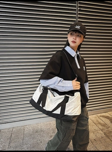 Outdoor shot of large capacity black and white travel bag with durable shoulder strap