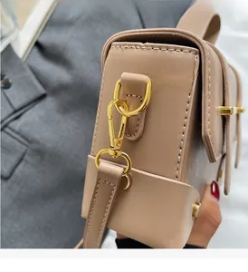 Close-up of elegant beige leather handbag with premium gold-tone metal hardware and stitching