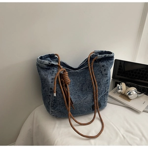 Vue détaillée d'un sac cabas en denim délavé avec anses en corde tressée et ordinateur
