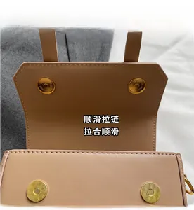 Close-up of light brown leather bag featuring four golden magnetic snap closures and texture