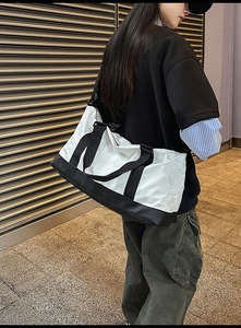 Street style shot of large travel bag with pleated texture and adjustable shoulder strap