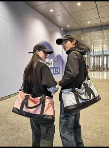 Detailed view of pink and silver large travel bags with monogram pattern and sturdy straps