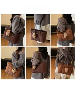 Detail of a brown suede tote bag with a cute plush bear pendant and leather straps