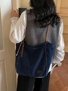 Sac fourre-tout en denim bleu foncé avec anses en corde marron et écusson en cuir