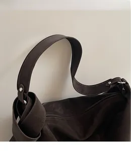 Gros plan détaillé du grand sac cabas marron foncé avec rivets argentés et bandoulière