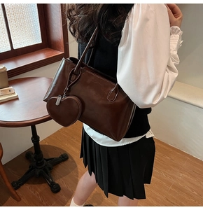 Detail of dark brown faux leather tote bag with a heart-shaped coin purse attachment