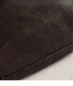 Gros plan des motifs floraux embossés sur le cuir marron foncé d'un grand sac cabas