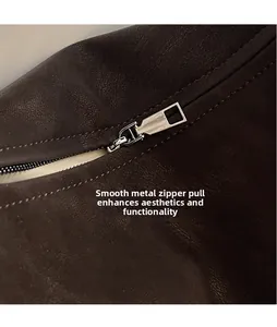 Vue macro du zip en métal argenté et de la texture du cuir du sac à bandoulière