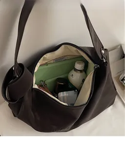 Détail de l'intérieur spacieux d'un grand sac cabas marron avec doublure en tissu doux