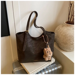 Détail du grand sac cabas marron vintage avec bandoulière et pendentif d'ours