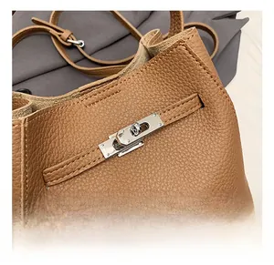 Macro shot of silver hardware twist lock on brown lychee grain leather bucket bag