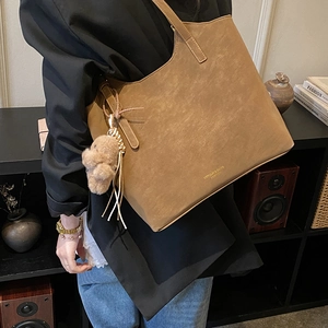 Gros plan du sac cabas marron avec logo HEPULIN & BAGS doré et breloque ours en peluche