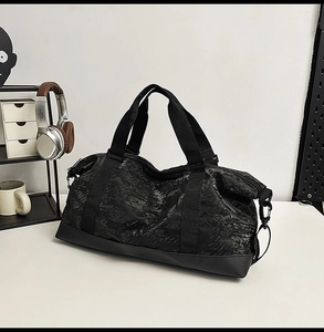 Macro shot of black textured gym bag featuring durable handles and metal D-ring details