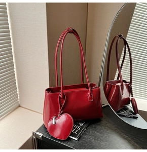 Macro shot of red glossy tote bag with a matching heart-shaped pendant charm