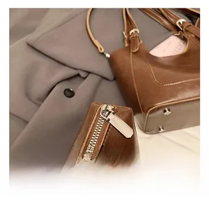 Detailed shot of brown leather bucket bag with silver hardware and metal studs