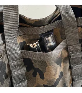 Détail d'un sac cabas camouflage avec poches de rangement et larges anses en toile