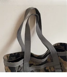 Gros plan du sac fourre-tout extérieur camouflage montrant des sangles grises robustes et du canevas