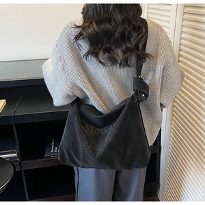 Détails de l'imprimé tournesol et lettres sur un sac cabas en daim noir