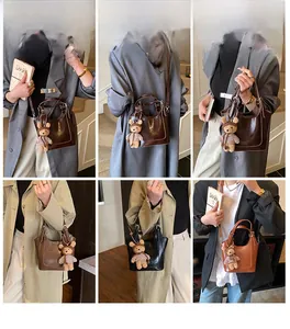 Three bucket bags in dark brown, black, and caramel shown on a model with bear charm