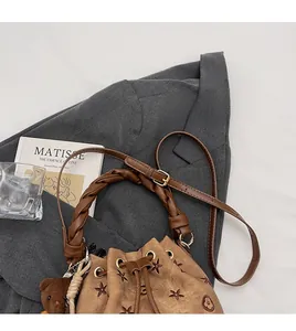 Detalle de bolso saco marrón vintage con bordado de estrellas y asa suave anudada