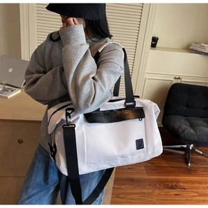 Large white travel duffel bag with black straps and weifeibag logo shown in a lifestyle setting