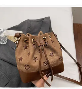 Detalle del bolso de lona bordado con base de cuero y cierre de cordón ajustable