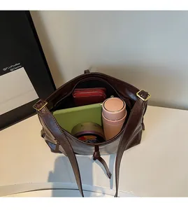 Spacious interior of a dark brown leather tote bag filled with daily essentials for work
