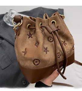 Detalle del bolso de cubo camel con bordados y cordón de cuero de primera calidad