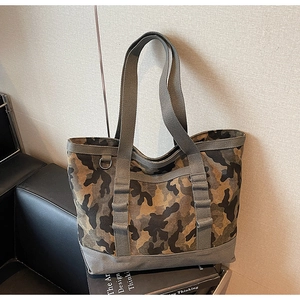 Détail du sac de rangement en toile camouflage avec poignées grises et anneau en D en métal