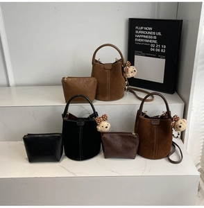 Detalle del conjunto de bolsos tipo cubo mate vintage con amuleto de oso en mármol